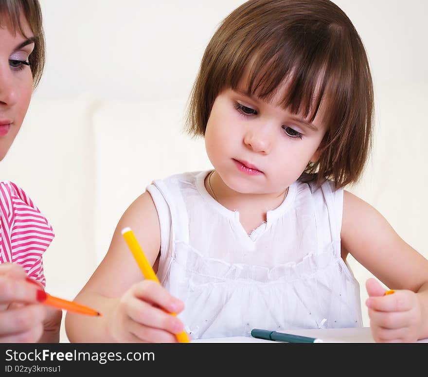 Mother and daughter together paint an album and have fun together.