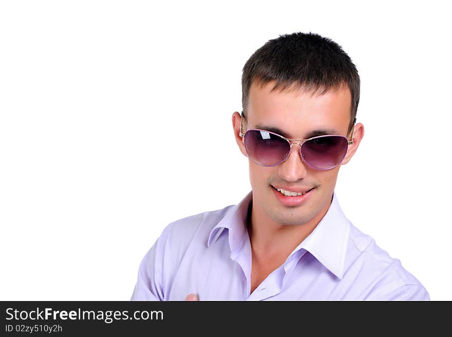 A young man in jeans and a light shirt and dark glasses