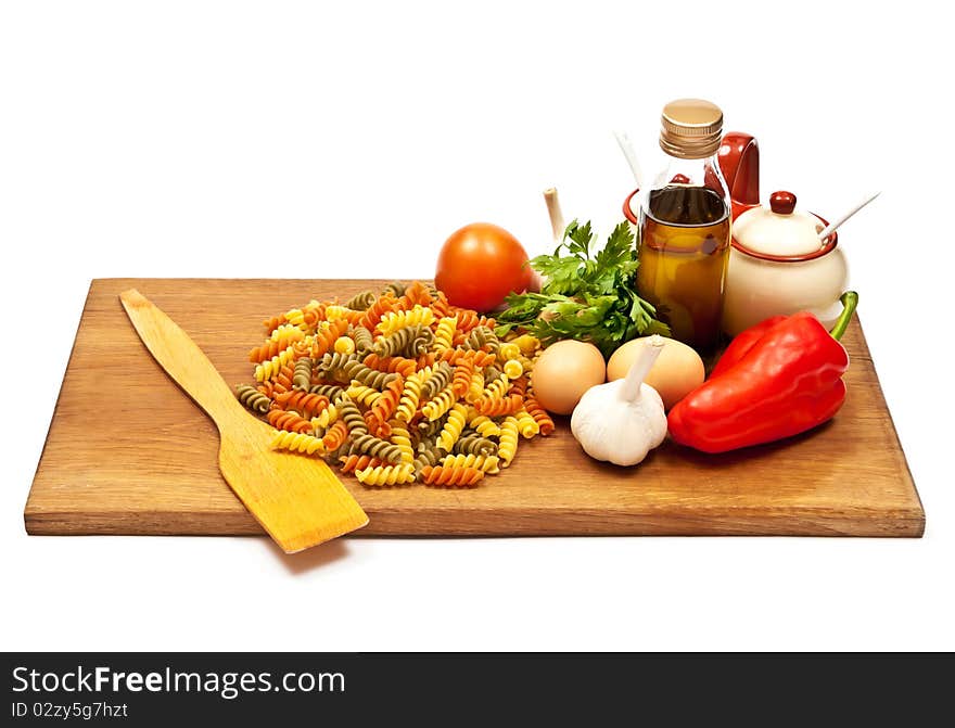 Close-up shot of spaghetti and vegetables on wooden board. Studio shot