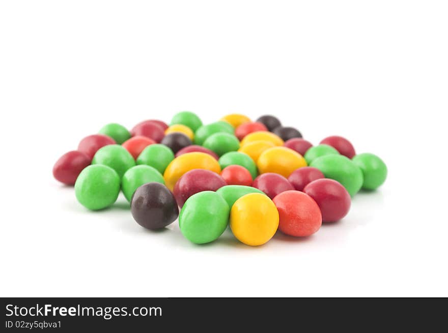 Pills with peanuts covered with multicolored glaze on a white background