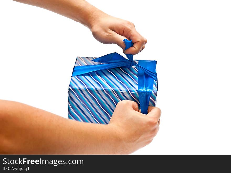 Isolated man's hands opening blue present. White background. Isolated man's hands opening blue present. White background