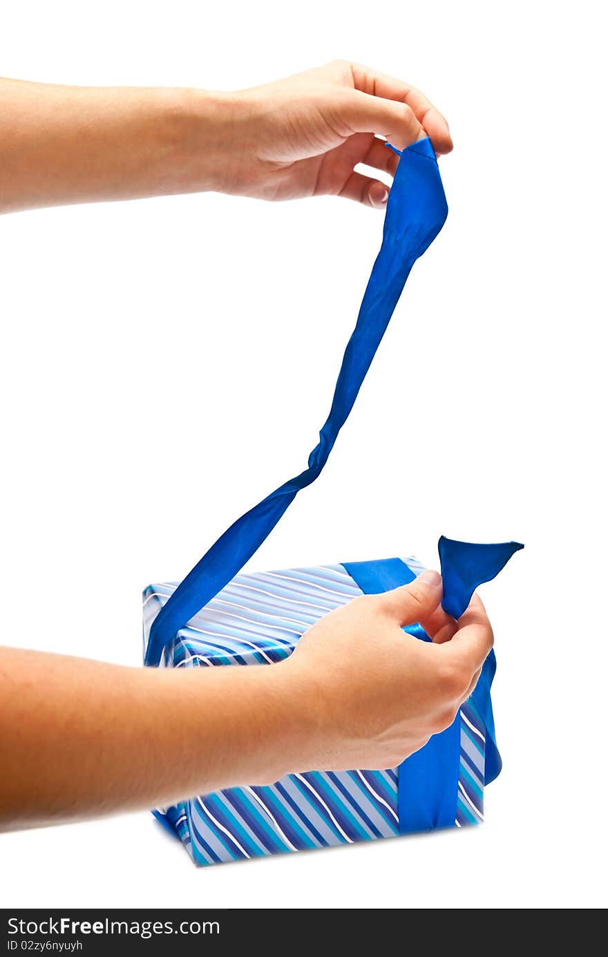 Isolated man's hands opening blue present. Studio shot. Isolated man's hands opening blue present. Studio shot