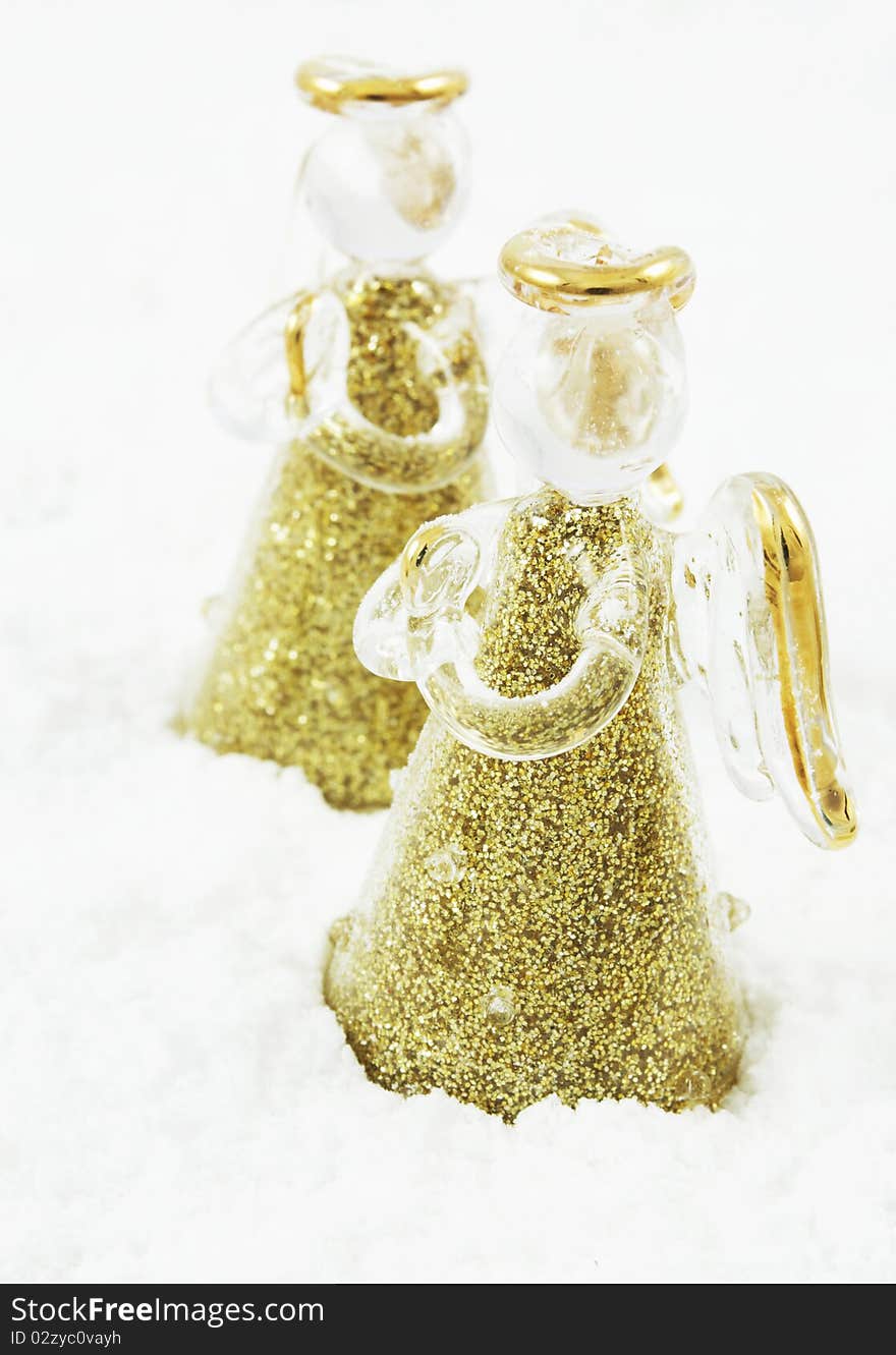 Golden glass angels in snow, decoration for Christmas