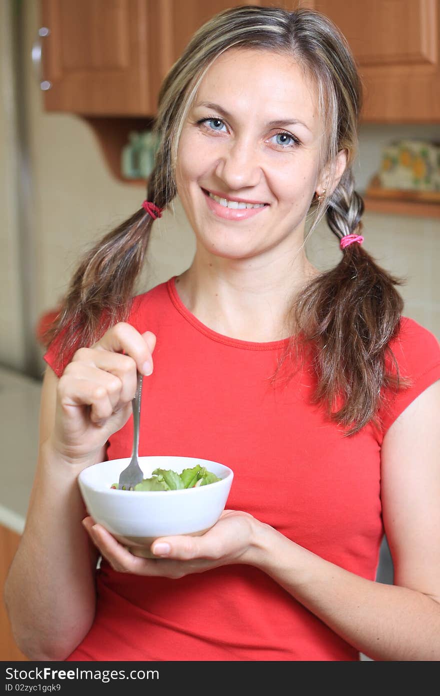 Portrait Of Young Happy Woman Eating Salad At Home