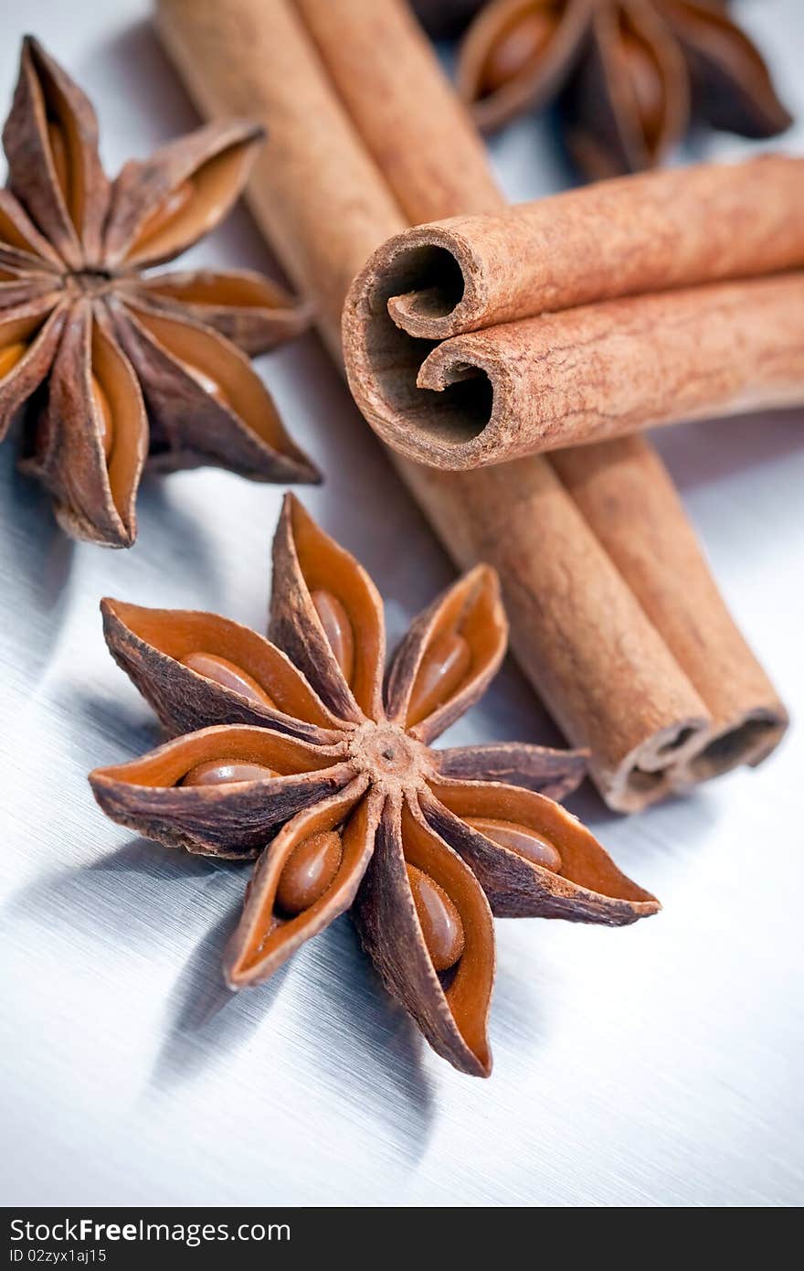 Cinnamon sticks and star anise on grey brushed metal background