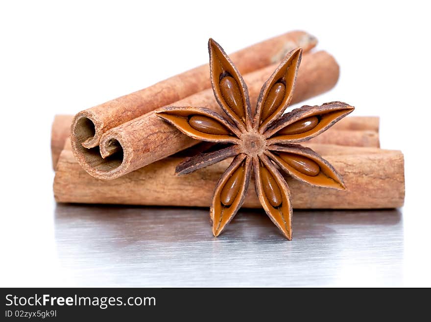 Cinnamon sticks and star anise on grey brushed metal background