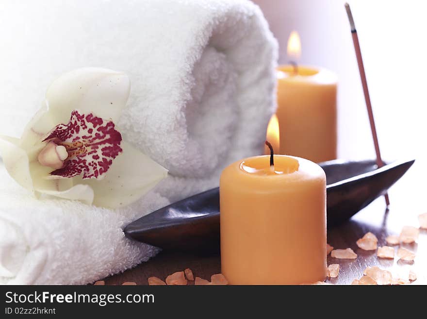 Spa setting with burning towel, candles and salt