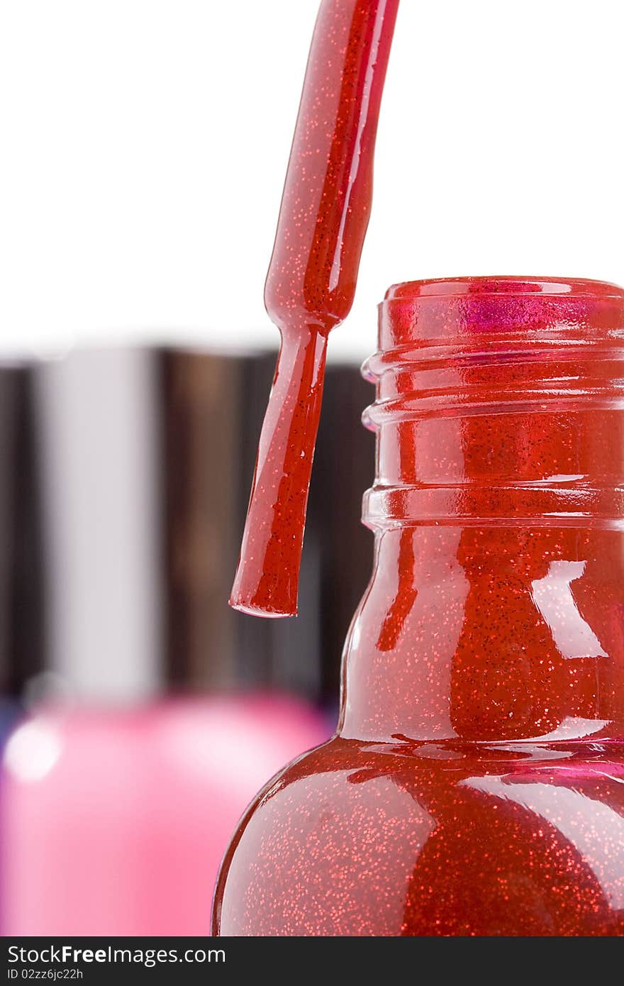 Open red nail polish bottle with a brush.