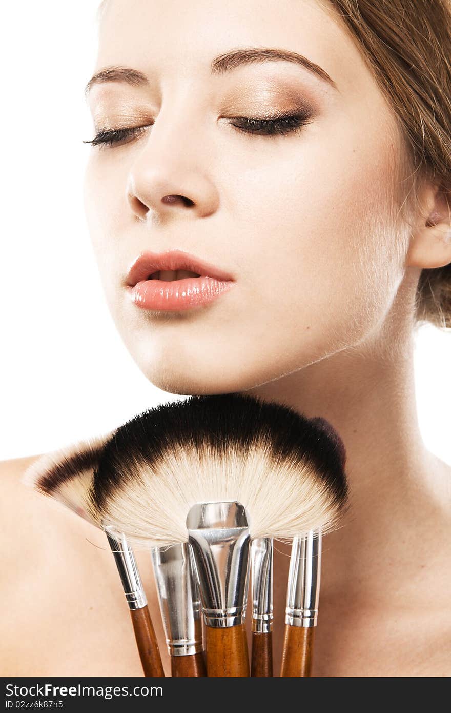 Closeup portrait of a beautiful young woman with makeup brushes. Closeup portrait of a beautiful young woman with makeup brushes