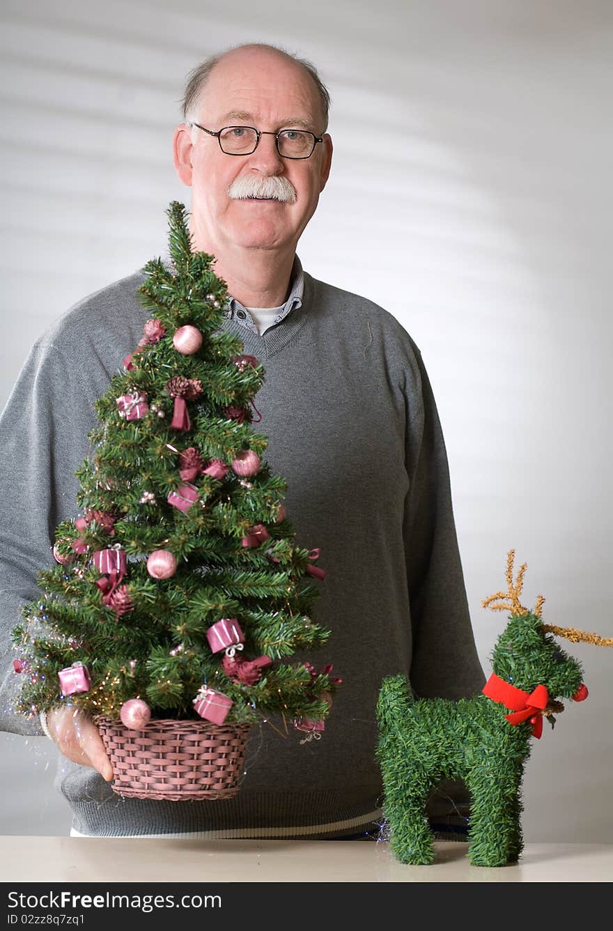 Senior man with christmas decoration on white