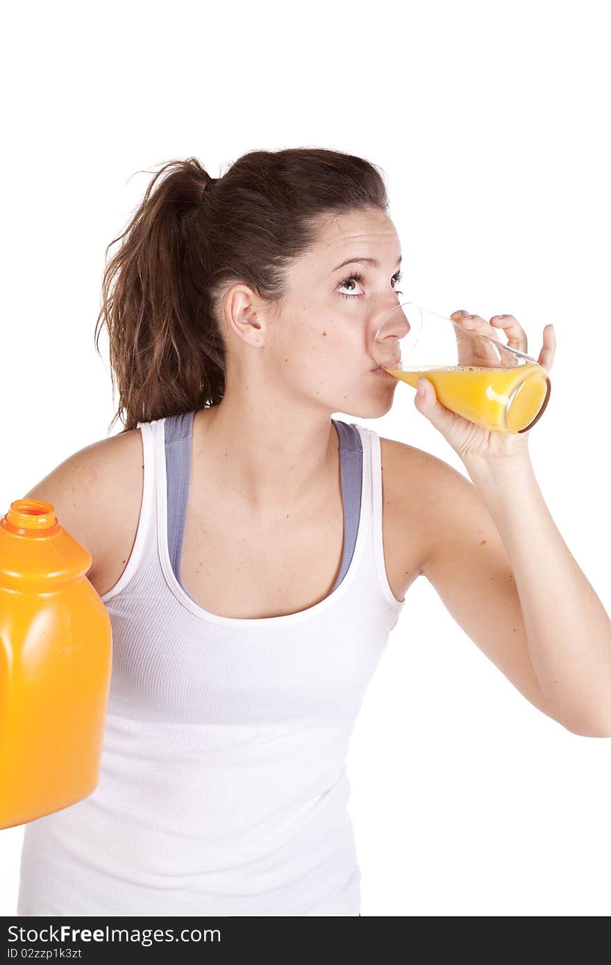 A woman in fitness attire is drinking orange juice. A woman in fitness attire is drinking orange juice.