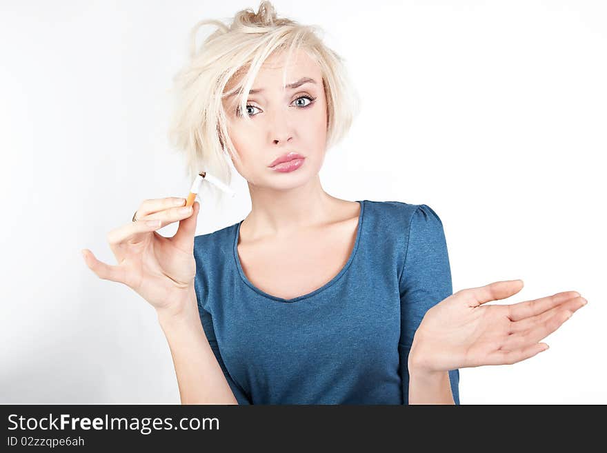 Worried blond lady holding a broken cigarette