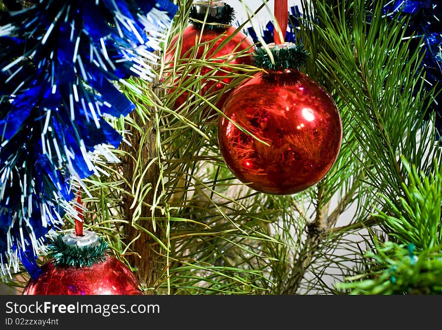 Two red glass balls and tinsel on Christmas-tree. Two red glass balls and tinsel on Christmas-tree