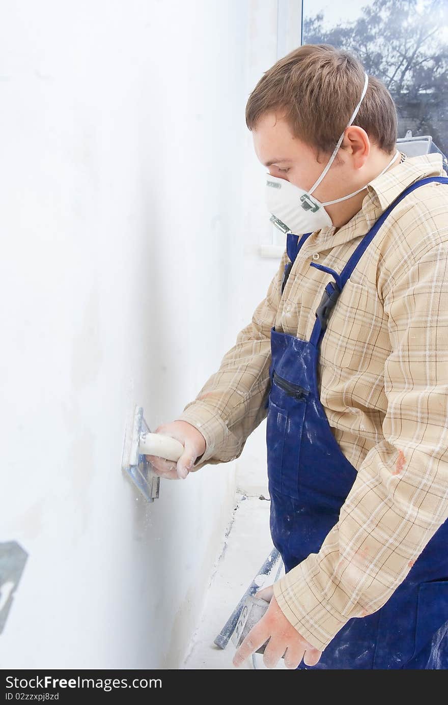 Young builder polishing the wall. house environment theme