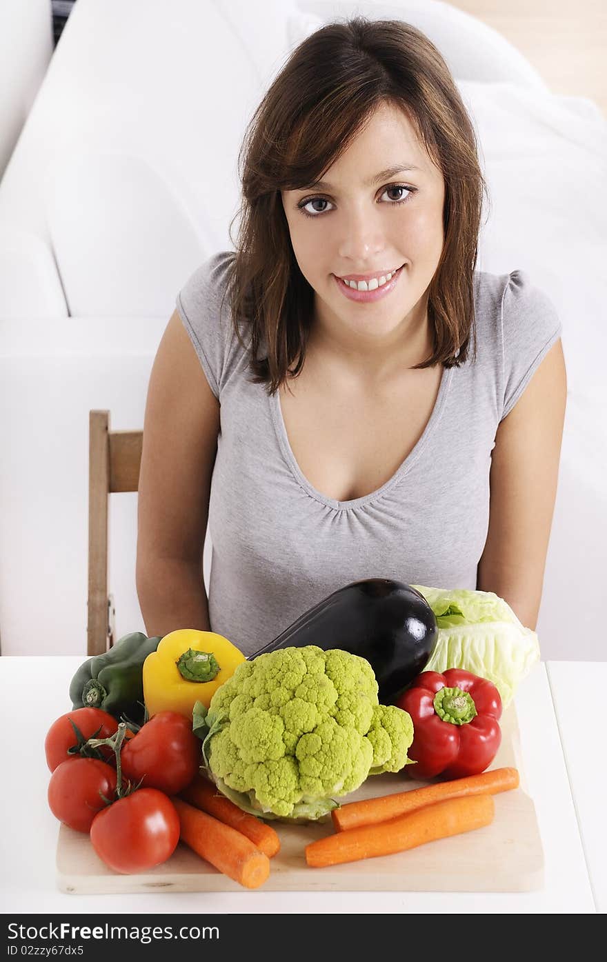 Young woman with raw vegetable smiling and looking in camera. Young woman with raw vegetable smiling and looking in camera