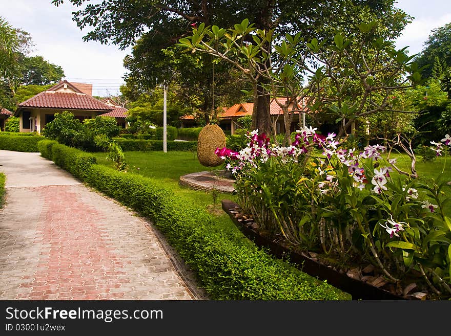 Front of resort on the beach in Thailand with orchid in foreground. Front of resort on the beach in Thailand with orchid in foreground