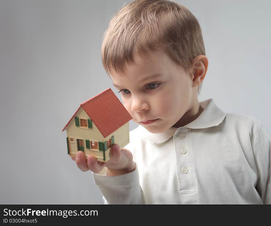 Child holding the model of a house. Child holding the model of a house