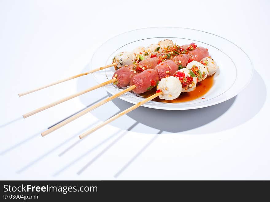 Pour sauce meatball skewers grill plate on a white background. Pour sauce meatball skewers grill plate on a white background.