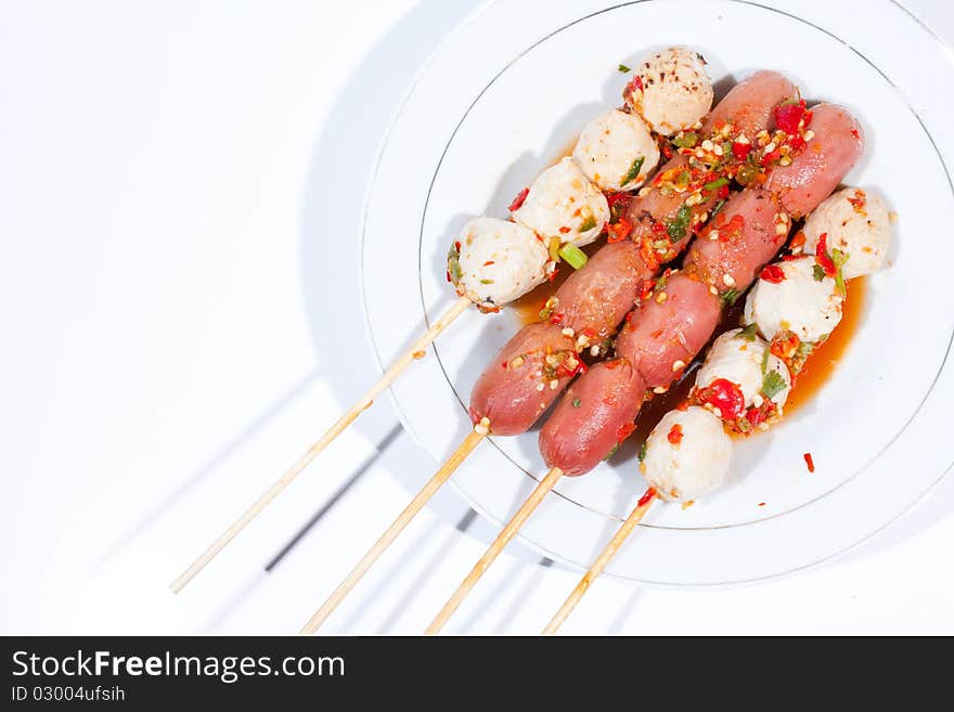 Pour sauce meatball skewers grill plate on a white background. Pour sauce meatball skewers grill plate on a white background.