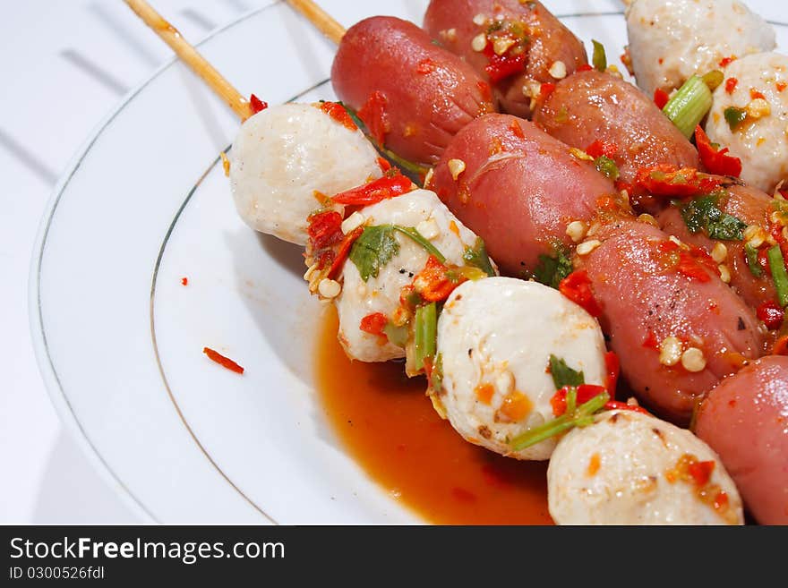 Pour sauce meatball skewers grill plate on a white background. Pour sauce meatball skewers grill plate on a white background.