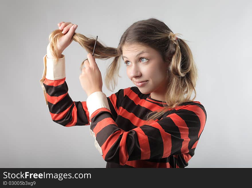 Beautiful woman cutting her hair. Beautiful woman cutting her hair