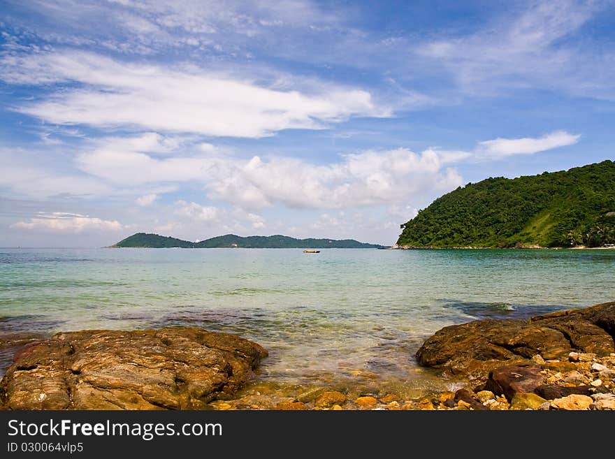 Sea with rock in foreground and island on far. Sea with rock in foreground and island on far