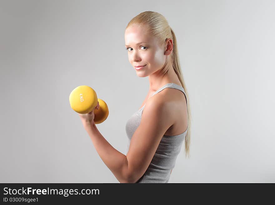 Beautiful young woman lifting weights. Beautiful young woman lifting weights