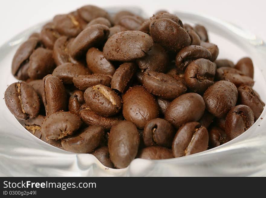 Coffee beans close-up over the glass dish