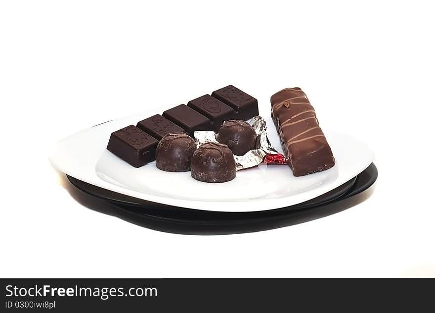 Various chocolate on a plate on a white background