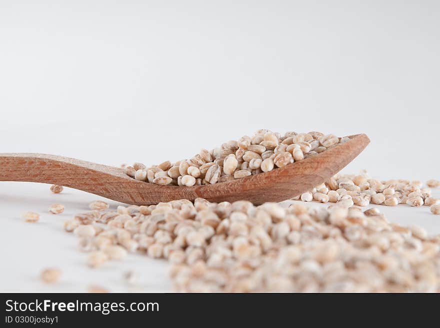 Grain spilled over a wooden spoon. Grain spilled over a wooden spoon