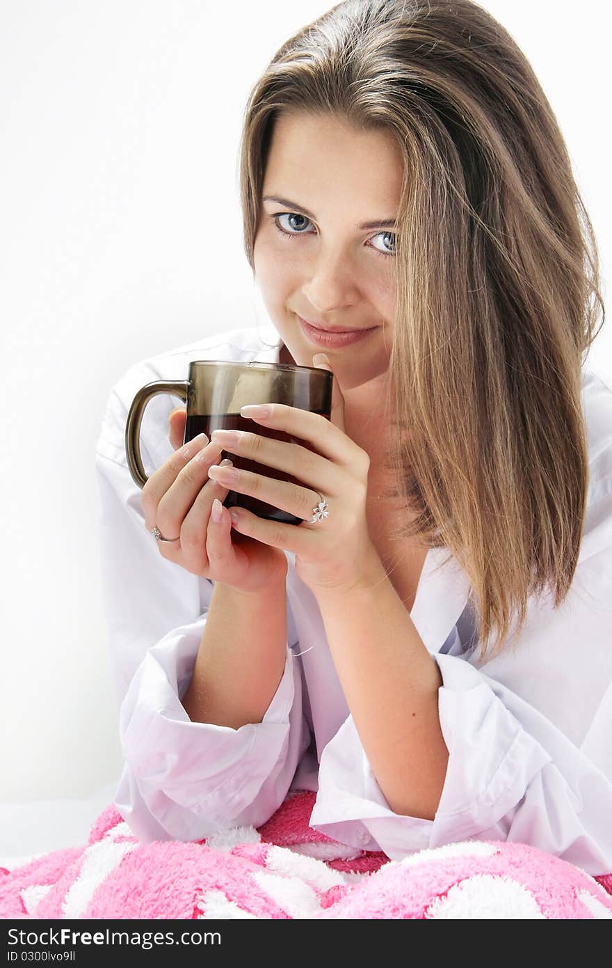 Young attractive girl with cup of tea in bed. Young attractive girl with cup of tea in bed