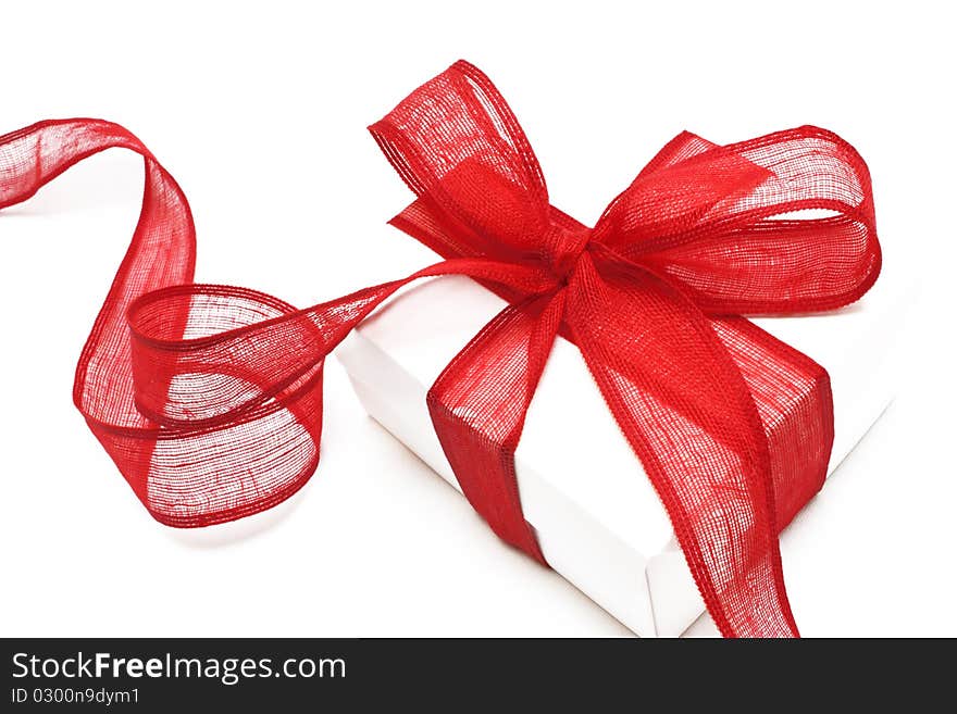 The white gift box with the red ribbon on the white background