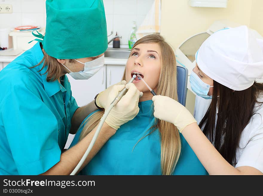 Shot of a young woman with dentists in a dental surgery. Healthcare, medicine. Shot of a young woman with dentists in a dental surgery. Healthcare, medicine.