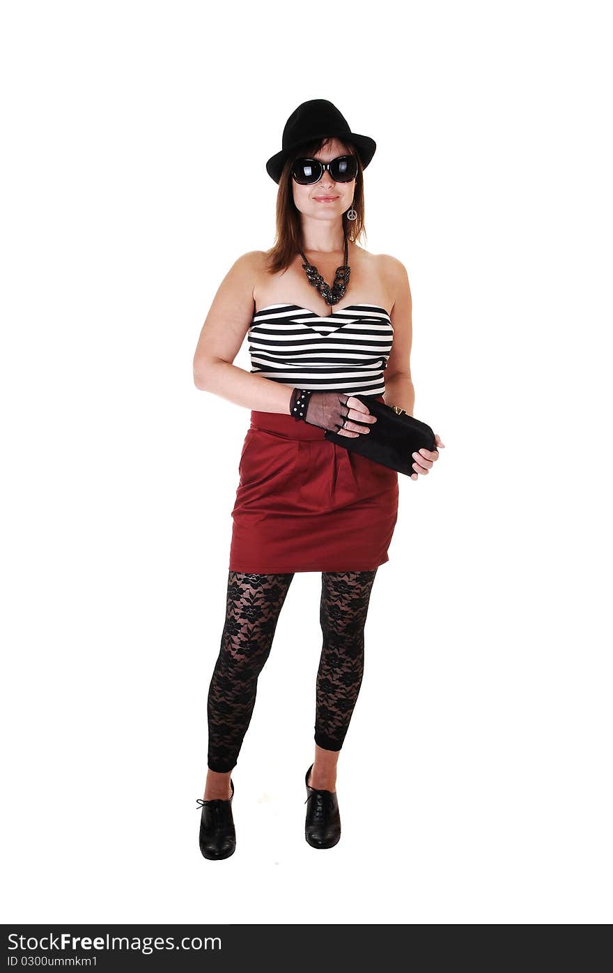 An middle aged woman in an short black and red dress and a gray hat standing for a portrait shot in the studio, for white background. An middle aged woman in an short black and red dress and a gray hat standing for a portrait shot in the studio, for white background.