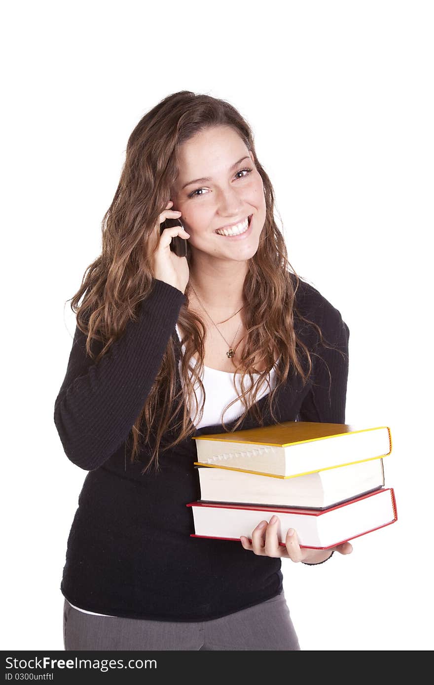 A business woman is holding books and talking on the phone. A business woman is holding books and talking on the phone.