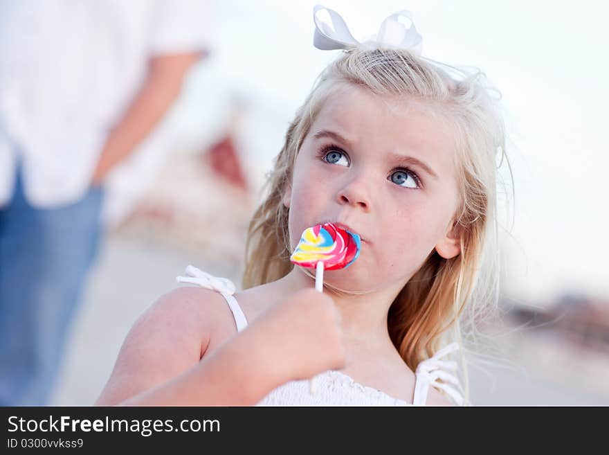 Adorable Little Girl Enjoying Her Lollipop Outside at the Beach.