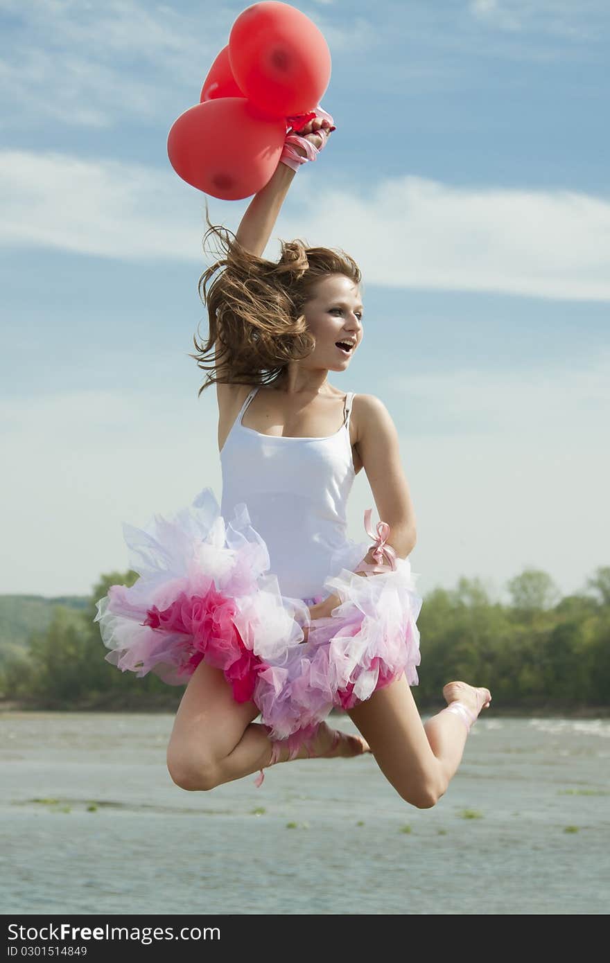 Young beautiful woman jumping with balloons.