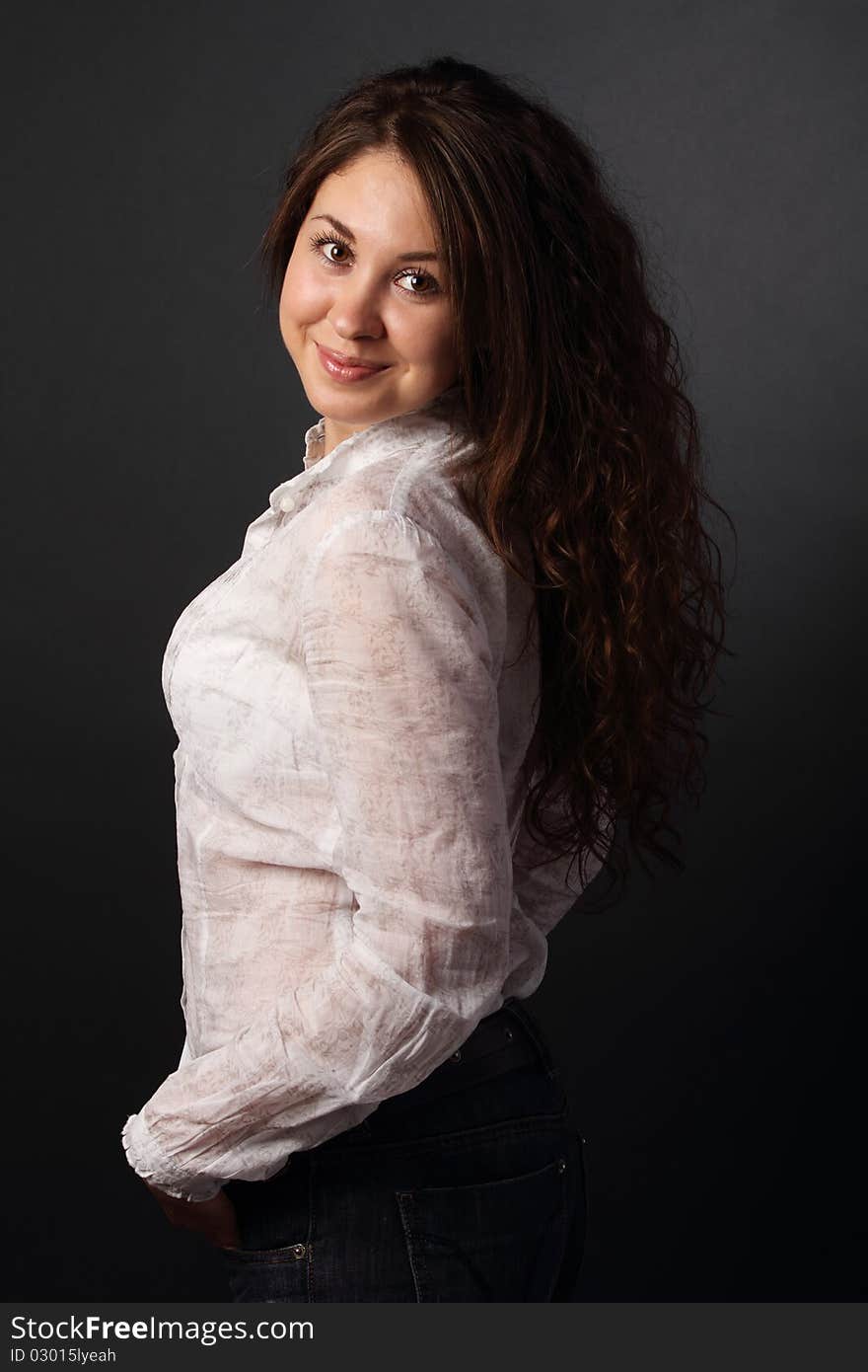 Portrait of the smiling girl over dark background