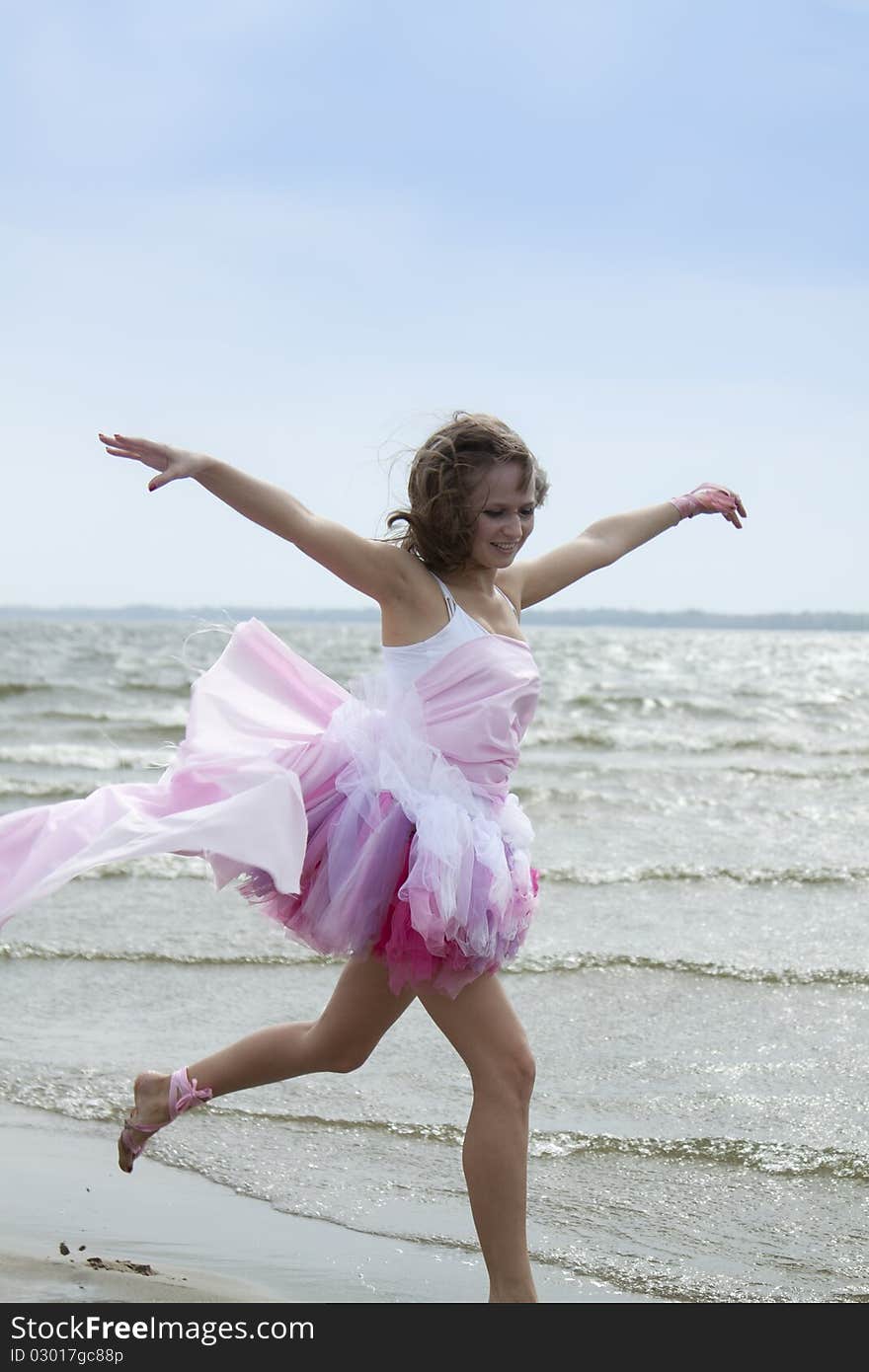 Young woman running through the water at the beach