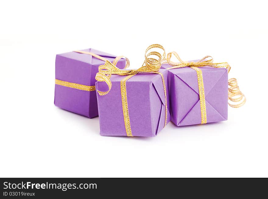 Lilac boxes with golden ribbon isolated on white background. Lilac boxes with golden ribbon isolated on white background