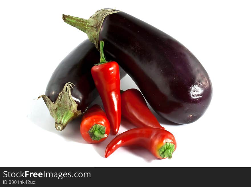 Eggplants and fresno peppers on a white background. Eggplants and fresno peppers on a white background