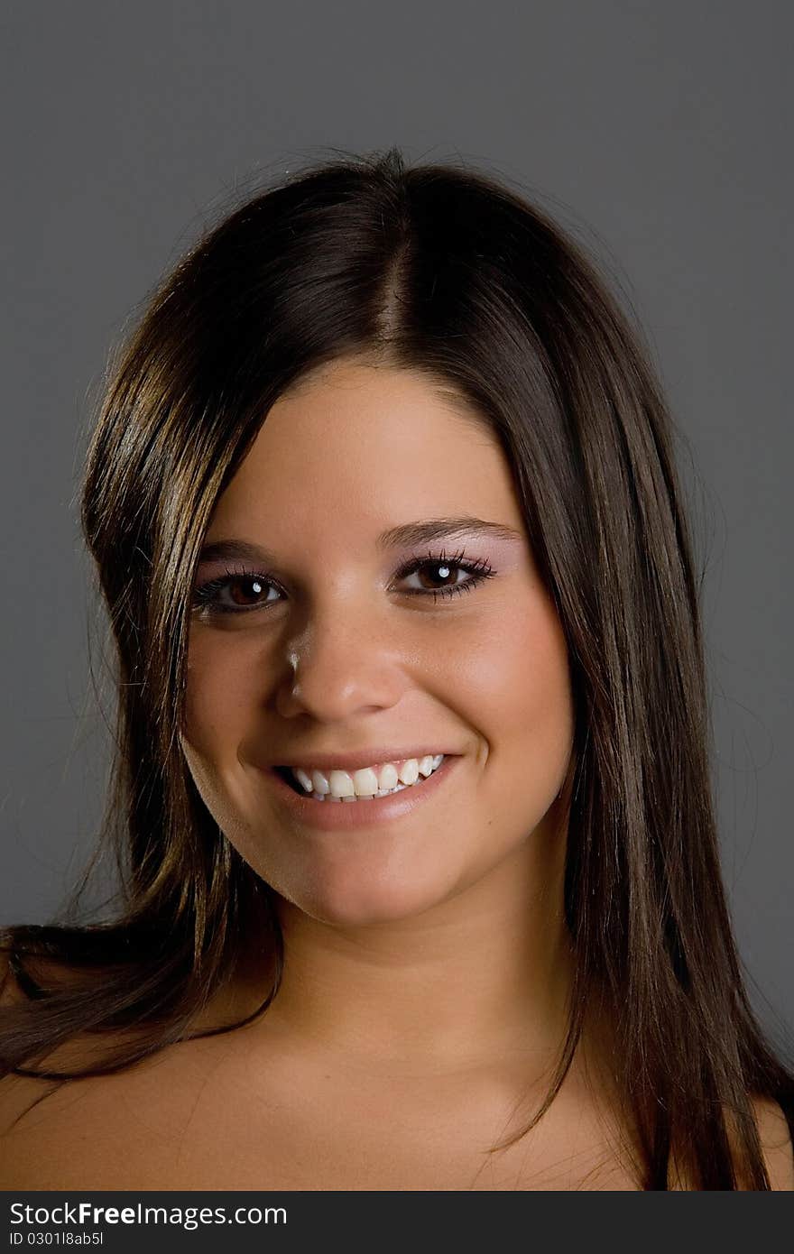 Young model posing in front of grey background in studio