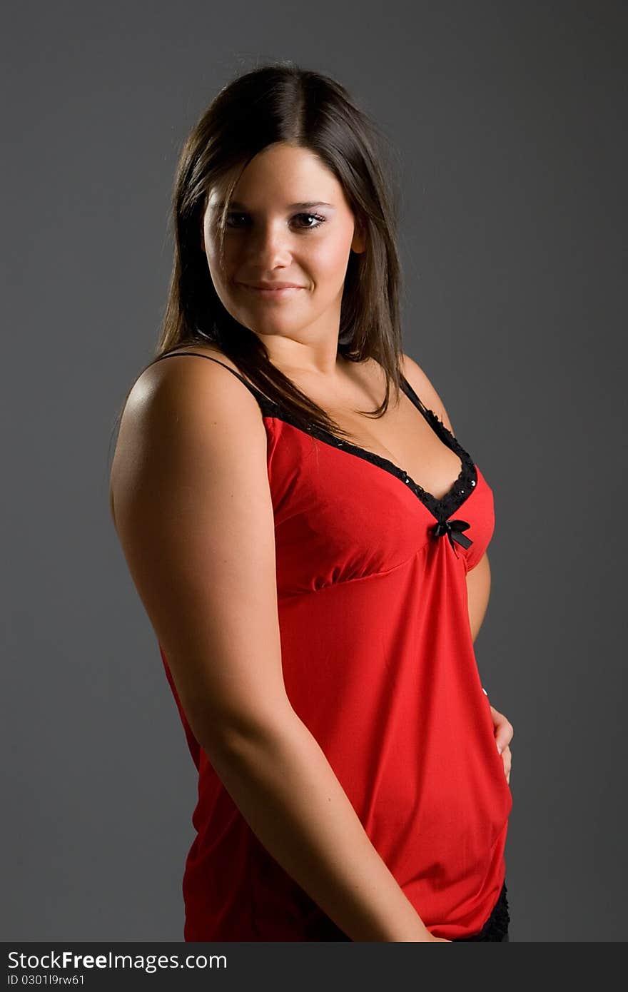 Young model posing in front of grey background in studio