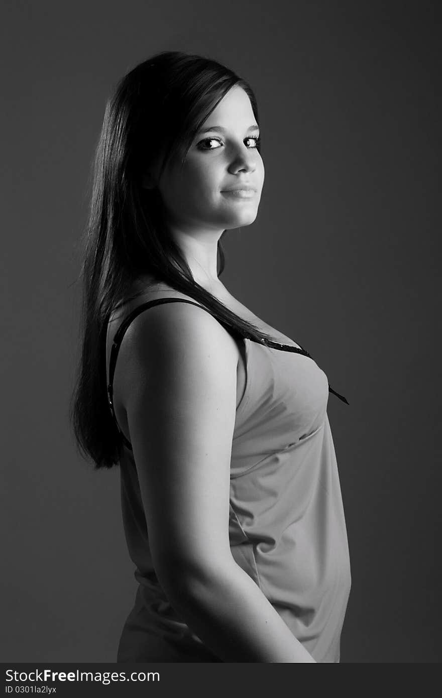 Young model posing in front of grey background in studio