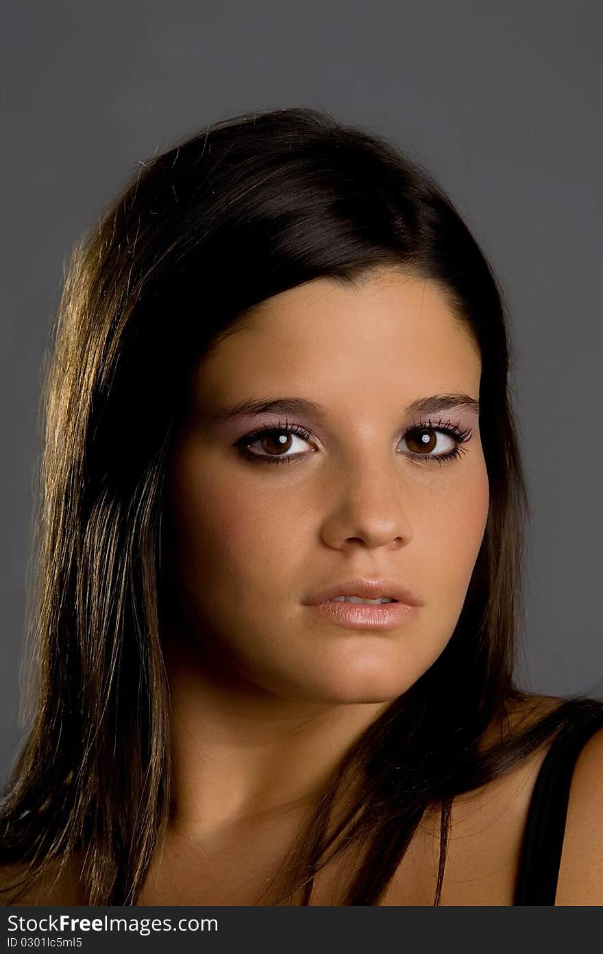 Young model posing in front of grey background in studio