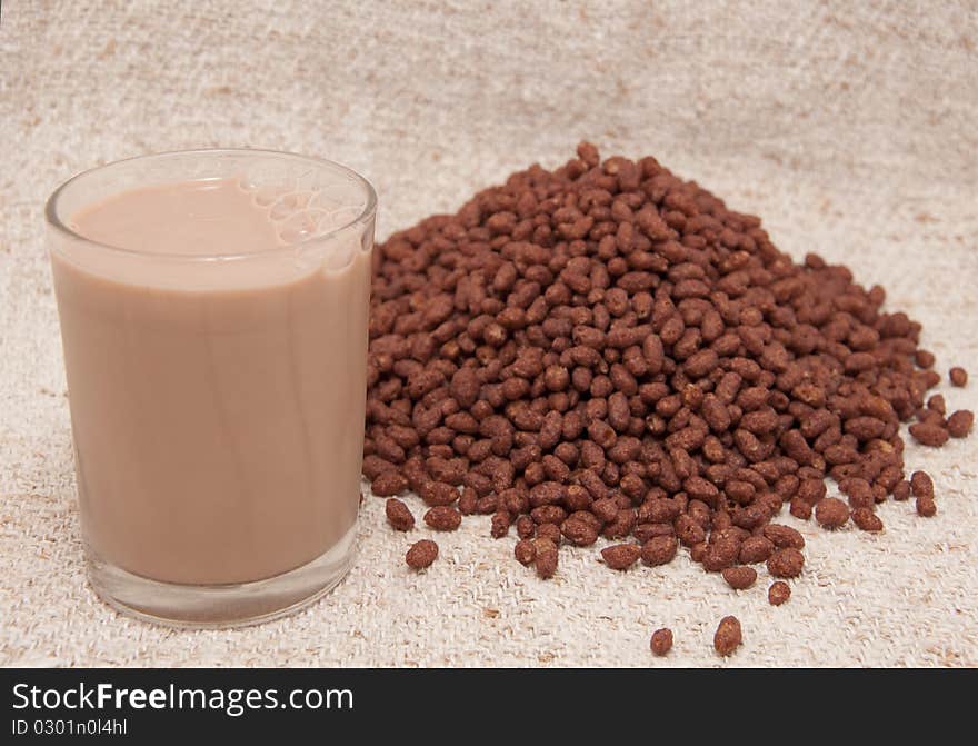 Beaker chocolate milk and cocoa rice crispies on the cloths of linen