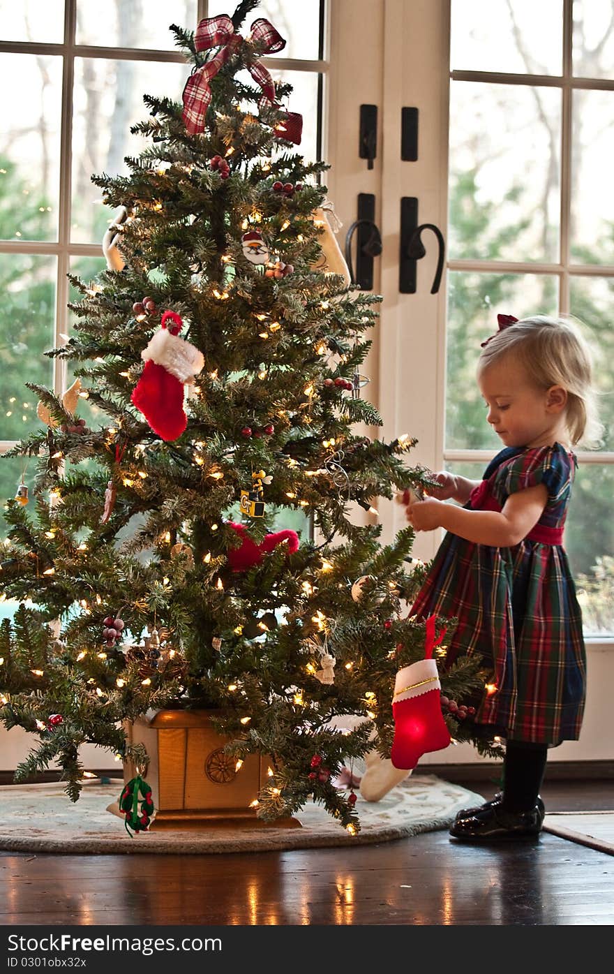 Little Girl Hanging Ornaments on a Christmas Tree. Little Girl Hanging Ornaments on a Christmas Tree