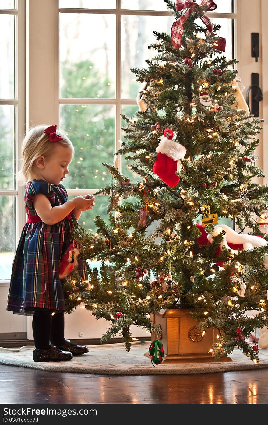 Little Girl Waiting for Santa in front of a Christmas Tree