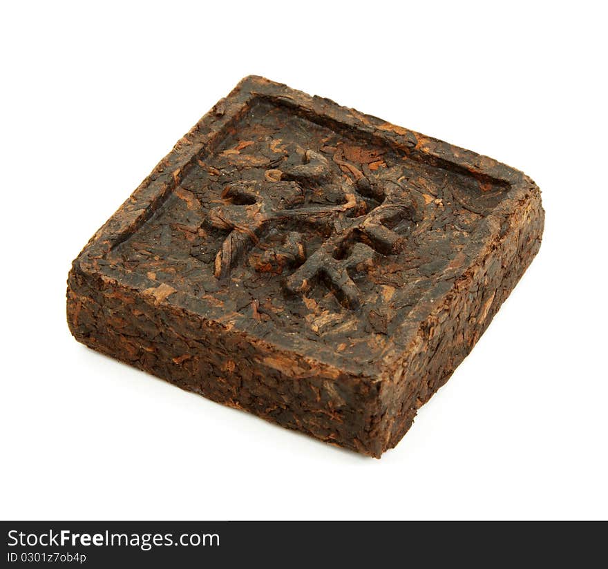 Pressed briquette of green tea with hieroglyphic on white background. Pressed briquette of green tea with hieroglyphic on white background