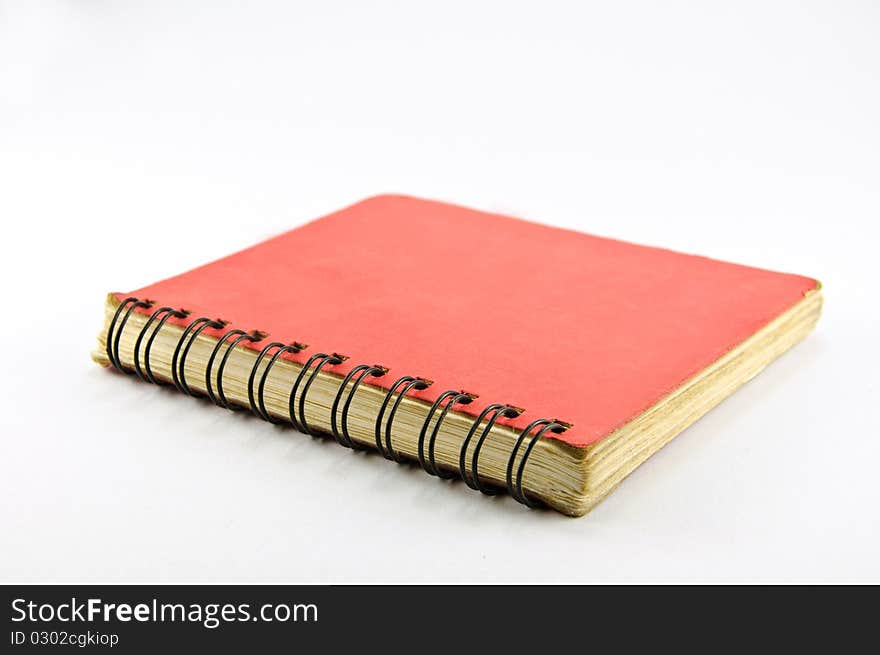 Old Red Spiral Notebook on white background